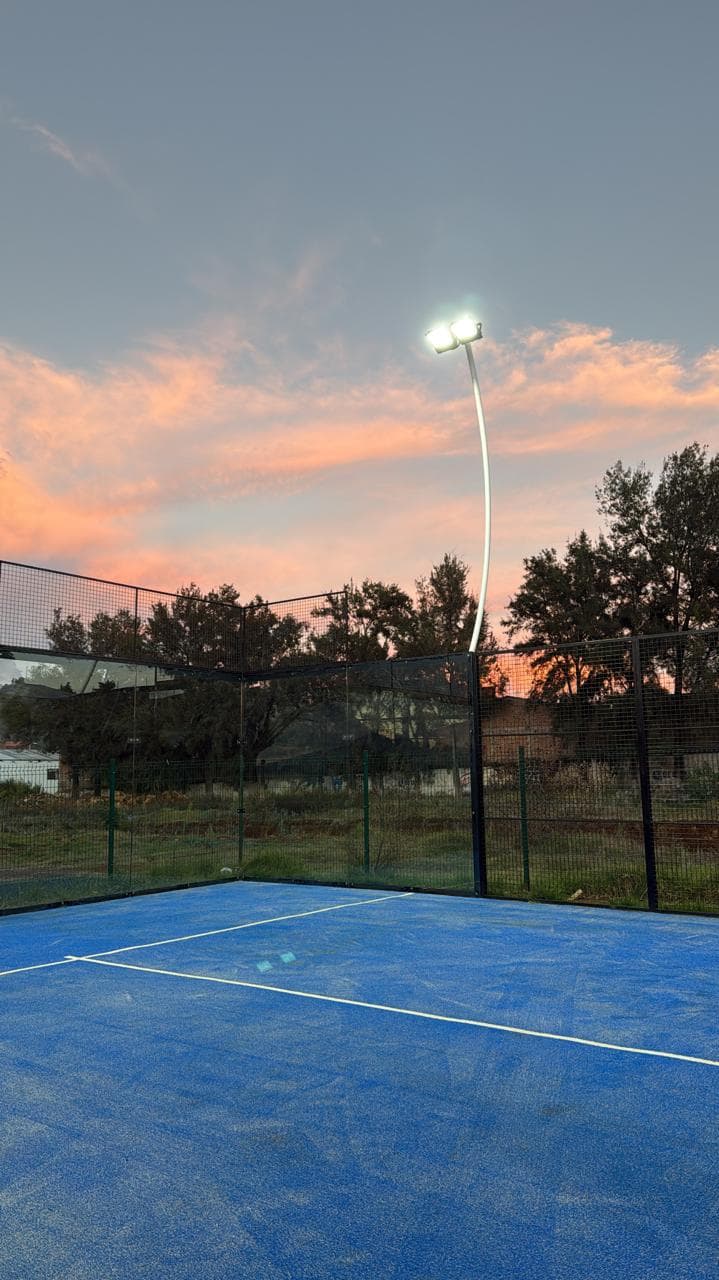 Reflector de torneo encendido sobre la cancha al atardecer